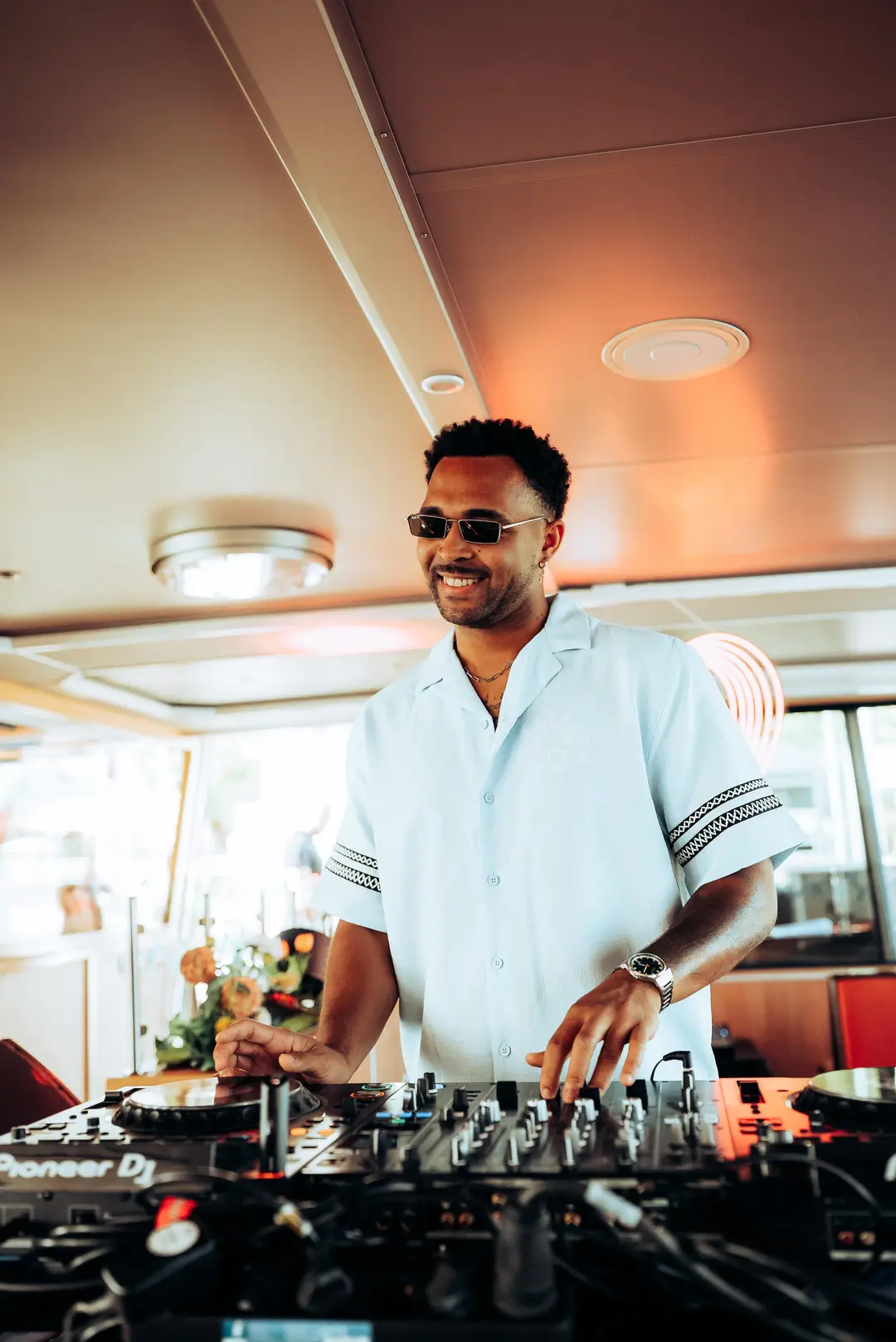 SEKOU in a light linen shirt at the decks on the boat